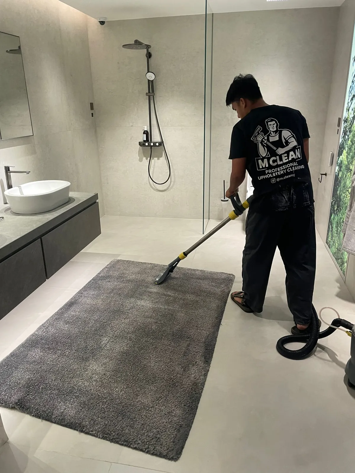 M Clean crew member cleaning a bathroom rug