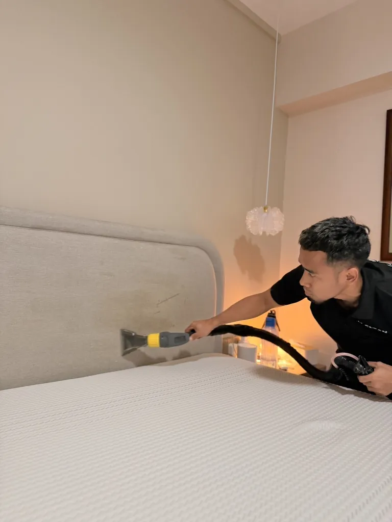 M Clean crew member extracting dirt from a fabric headboard
