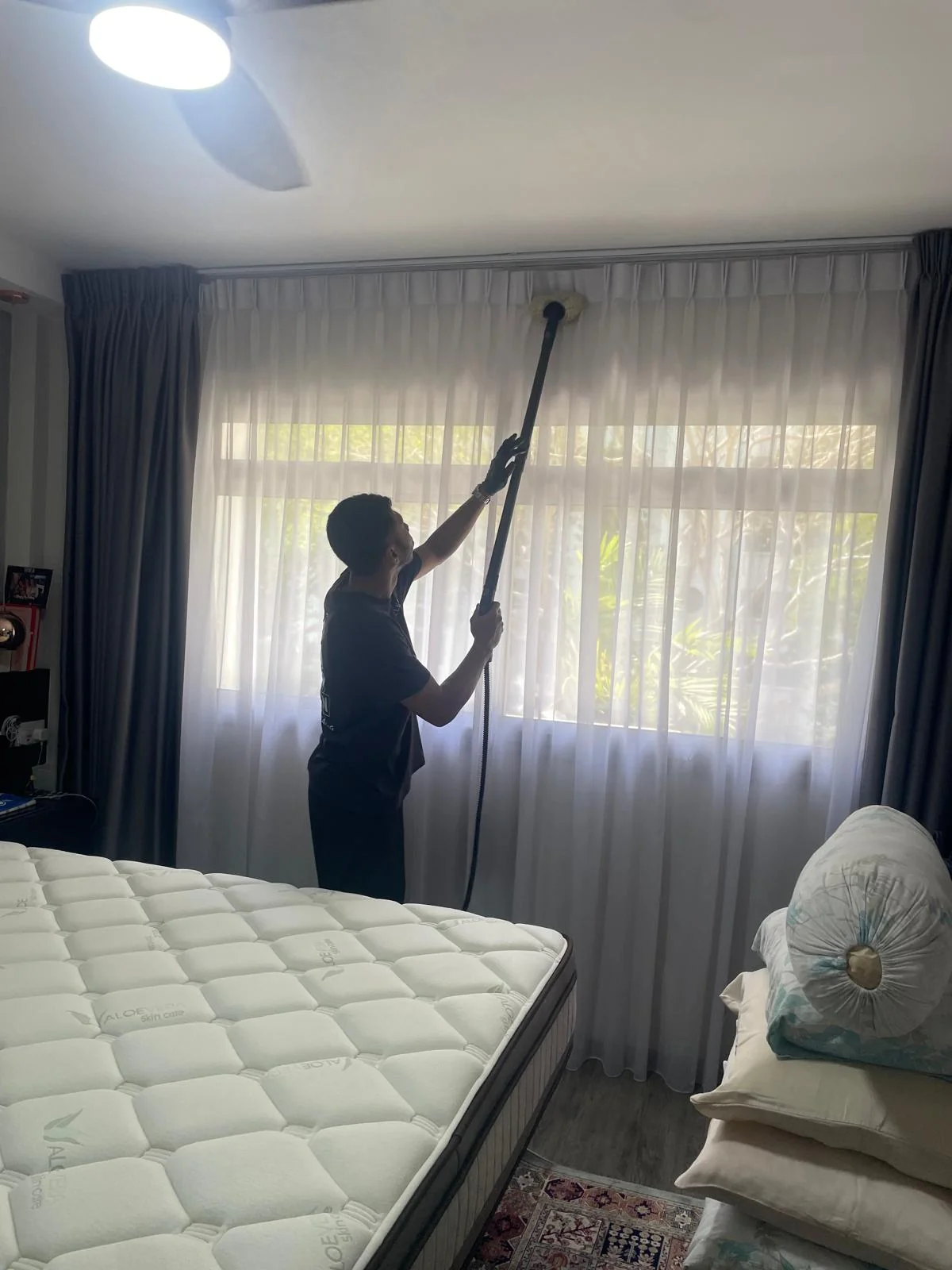 Professional curtain steam cleaning and dust mite extraction in progress