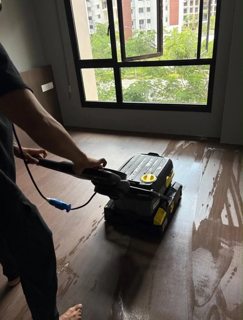 Floor scrubber on a dark wooden floor in a new flat