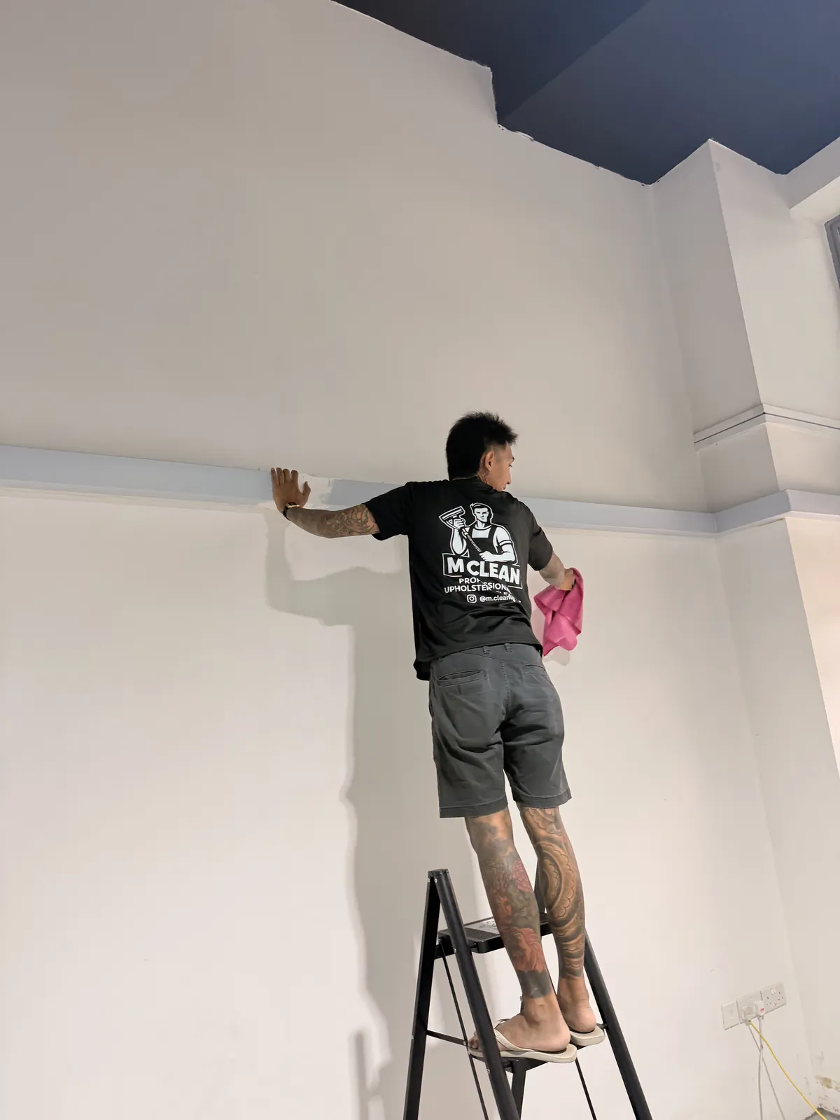M Clean crew member wiping an office wall