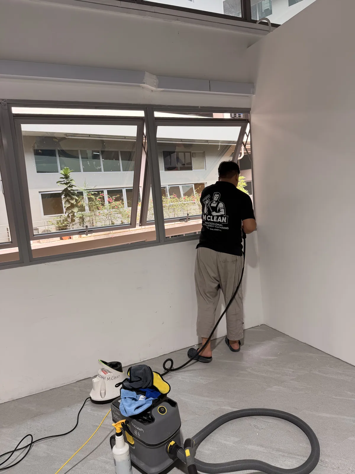 M Clean crew member cleaning office windows