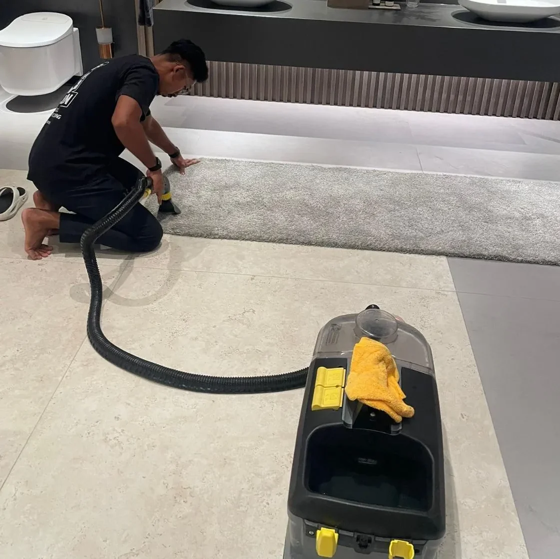 M Clean crew member extracting dirt from a rug in a showroom